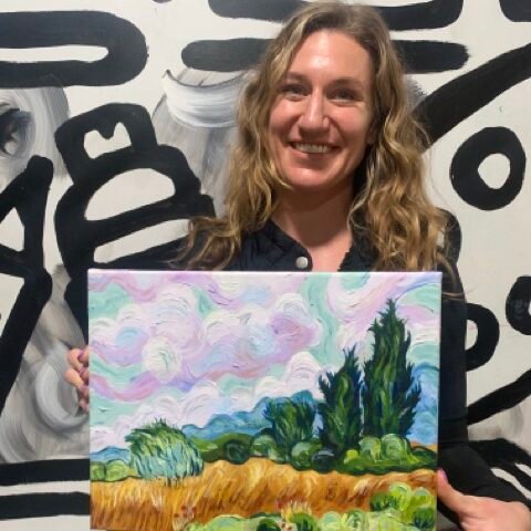 Open Studio 2 A woman holding a painting from our Adult Art Classes in San Diego