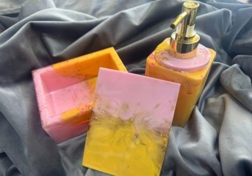 Colorful resin soap dispenser and matching trinket boxes with marbled pink and yellow finishes created during the Resin Soap Dispenser & Trinket Box workshop at the Artist Outpost in Ocean Beach.